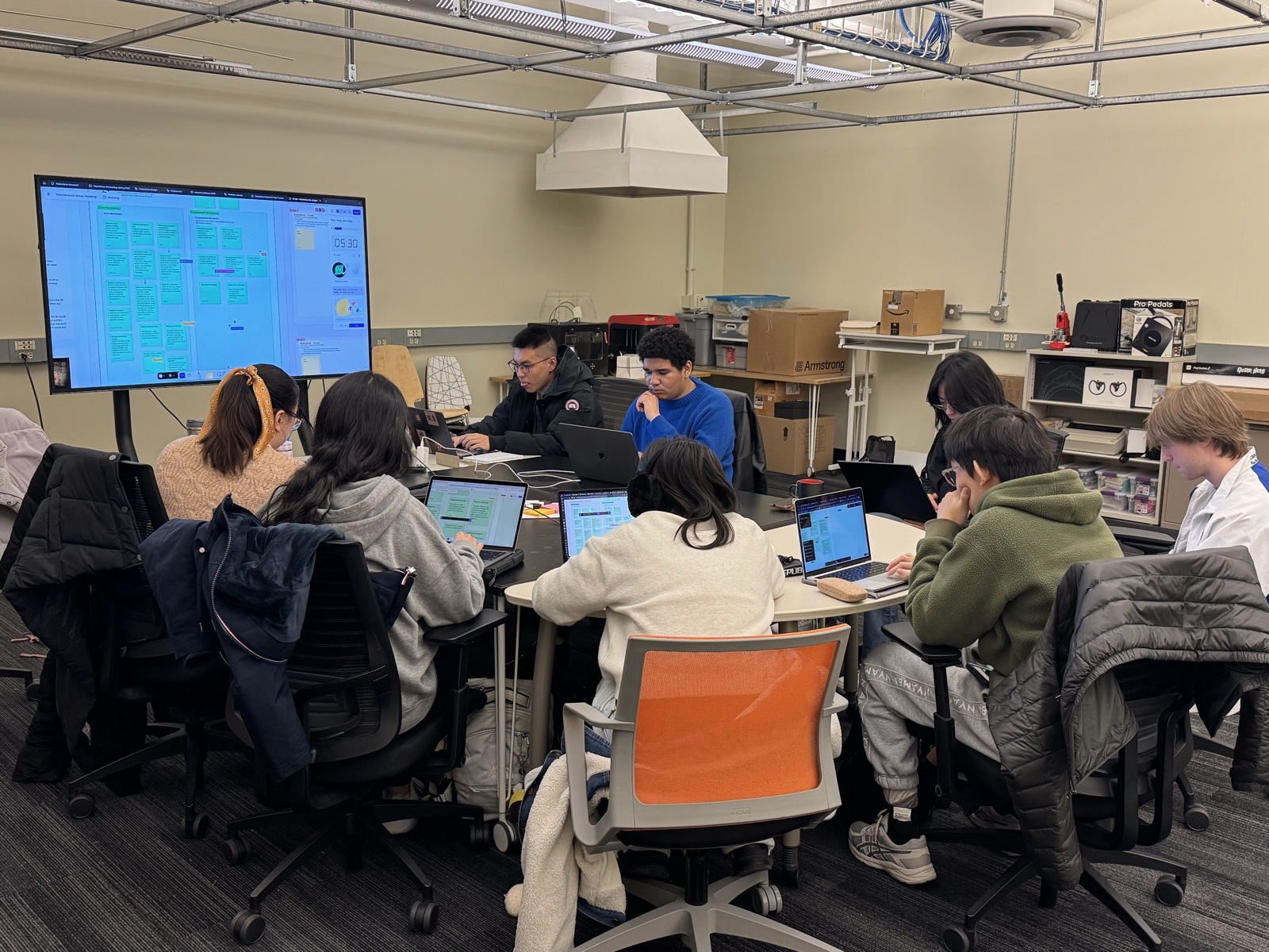 The TokenVerse team working together around a table, reviewing the project board on a shared screen